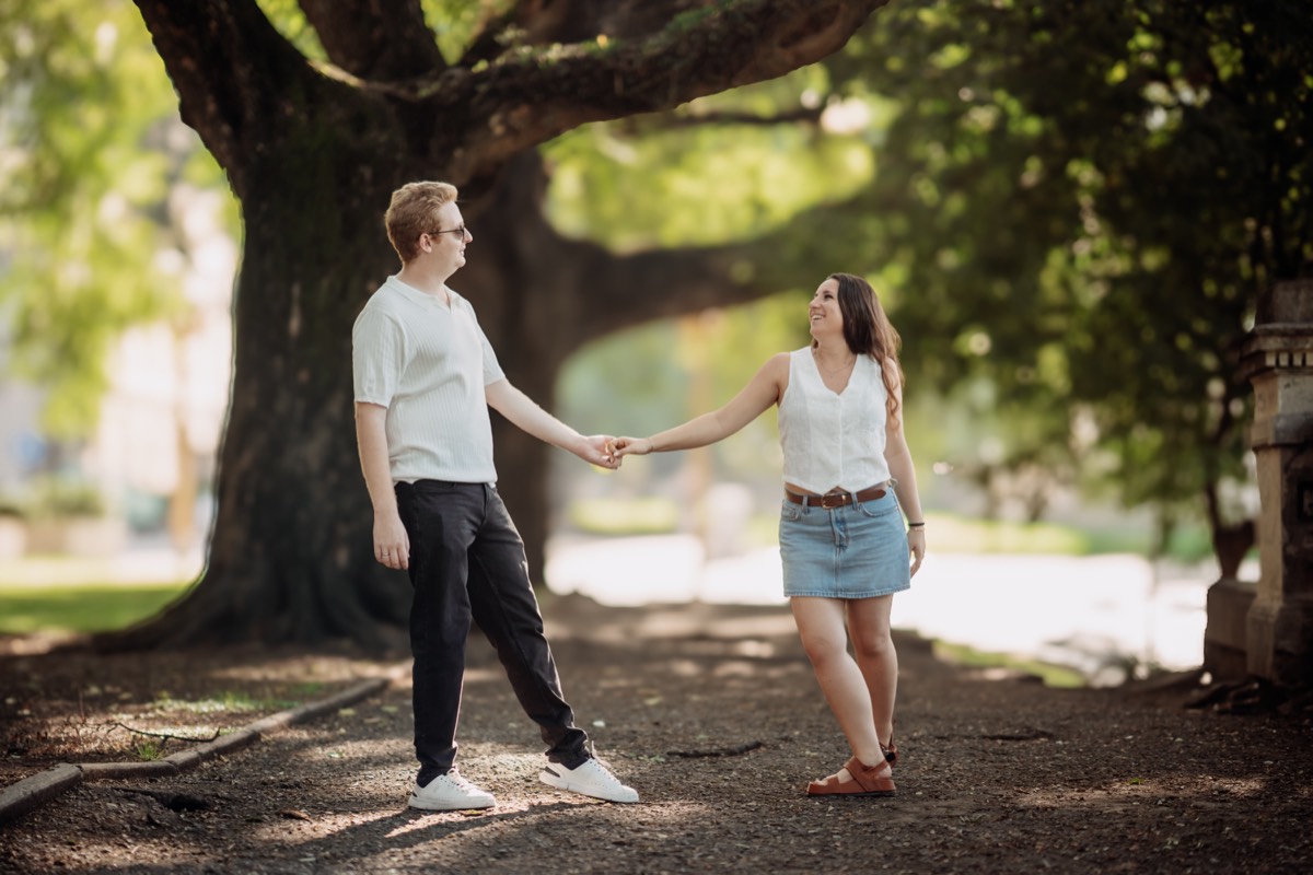 Niki y Dylan de la mano bajo los árboles, en Buenos Aires